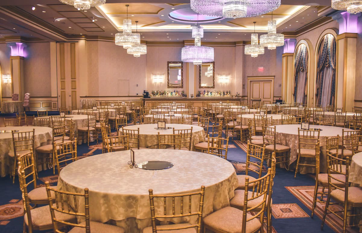 Illustration of a ballroom with round tables and warm lighting